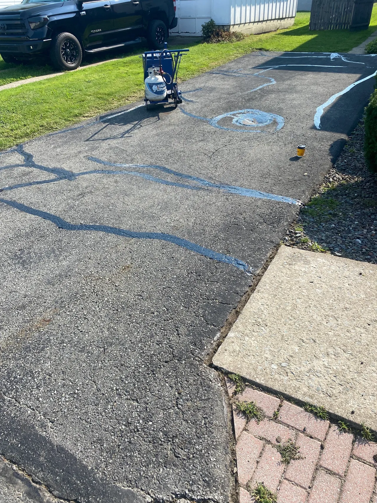 Driveway before repair โ visible cracking and surface damage