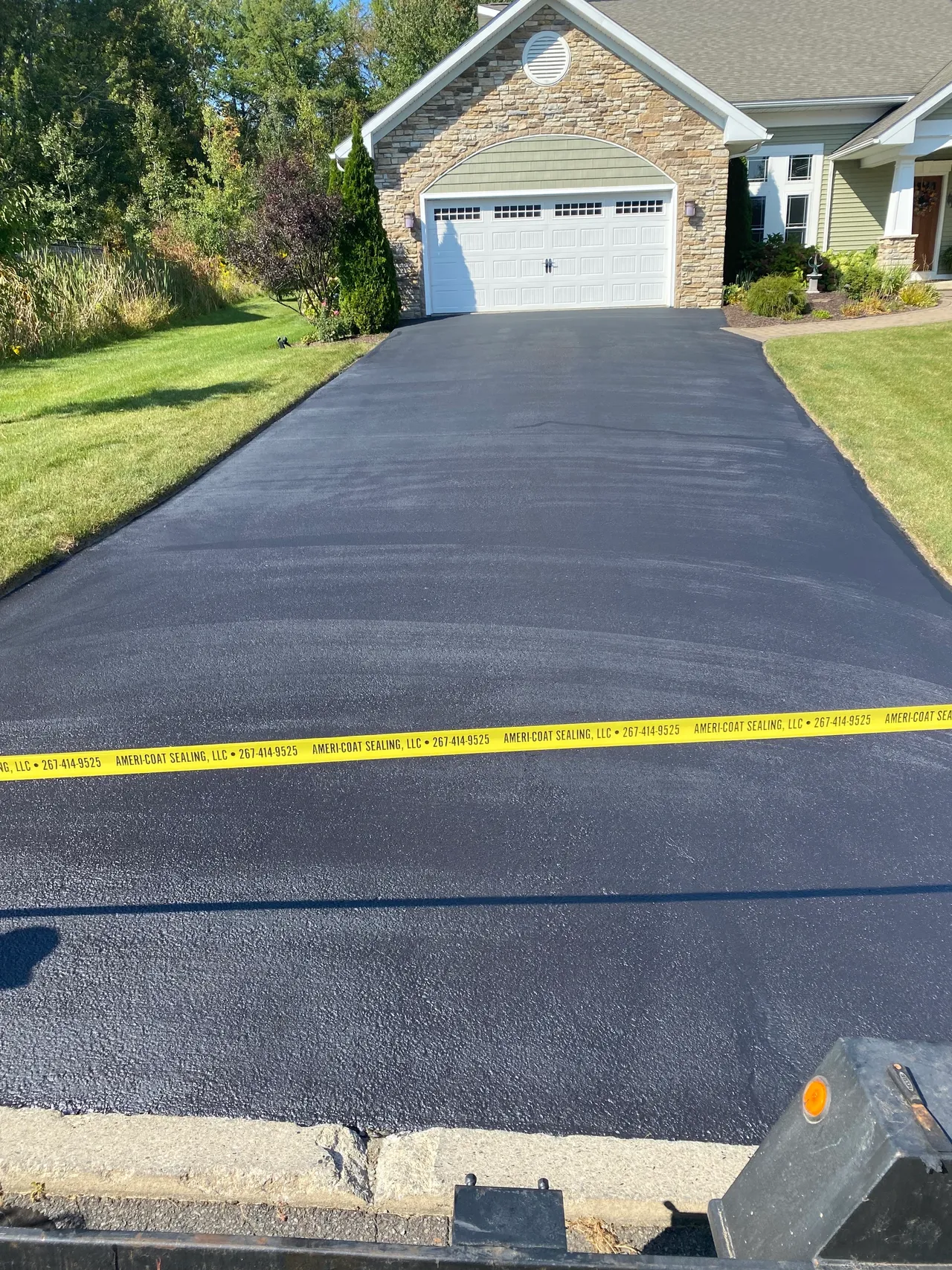 Stone front house driveway sealed by Ameri-Coat